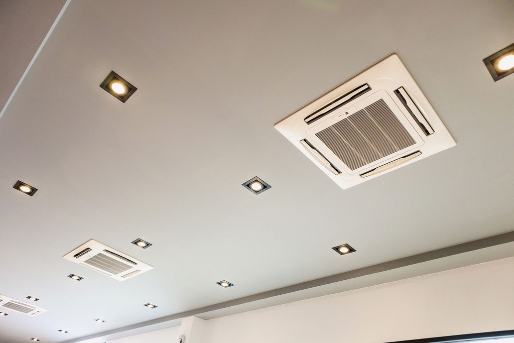 Ceiling-mounted commercial air conditioning in an office with a suspended ceiling